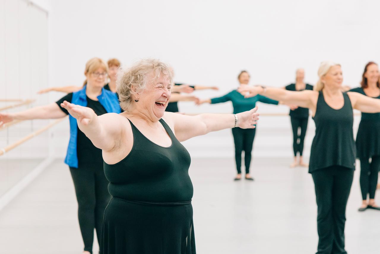 Silver Swans ballet participants practising at the barre in a community hall