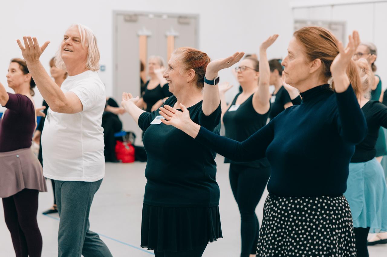 Adult ballet class enjoying coordinated dance movement together